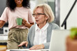 © Svitlana - Close up of aged woman, senior intern talking to her young colleagues, Friendly workers listening to new employee during coffee break at work