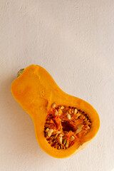 Wall Mural - Fresh organic pumpkin cut into pieces on light concrete background