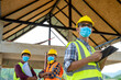 © visoot - Group of engineering team wearing protective face masks for safety meeting at building site.