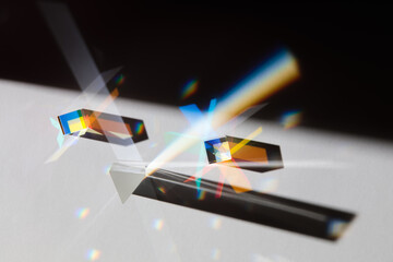 Glass geometric figures prisms with light diffraction of spectrum colors and complex reflection with trendy light and hard shadows on a white background