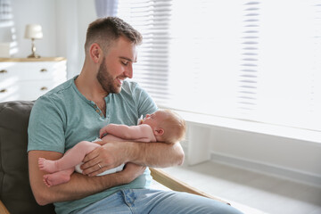 Wall Mural - Father with his newborn son at home. Space for text