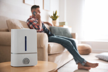 Wall Mural - Modern air humidifier and blurred man on background