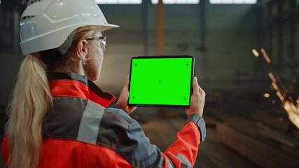 Aufkleber - Professional Heavy Industry Engineer Uses Tablet Computer with Green Screen Mock Up Display. Female Industrial Specialist Working in a Metal Manufacture Warehouse with Sparks in the Background.