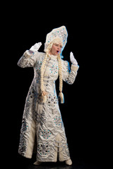 Snow Maiden in a white fur coat, kokoshnik and long hair braids holding a Santa Claus gift, posing on a black background