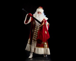 Santa Claus in a red fur coat, with a white beard posing on a black background