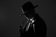 © New Africa - Old fashioned detective with smoking pipe on dark background, black and white effect