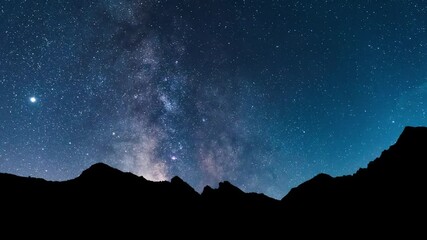 Milky way panorama above the mountains. Time lapse video of the night starry sky with the milky way, stars, planets and constellations in motion. Immensity of the deep universe.