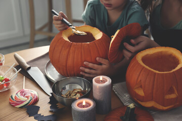 Canvas Print - Mother and daughter making pumpkin jack o'lantern at table, closeup. Halloween celebration