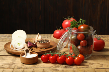 Pickling jar with fresh ripe cherry tomatoes and spices on wooden table