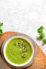 Sticker - Green vegetable cream soup in a white bowl on a gray concrete background top view. Free space for text. Vegan soup puree of green vegetables. Vegetarian and diet food. Copy space.