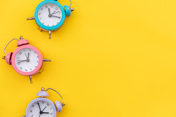 Wall Mural - Simply minimal design three ringing twin bell classic alarm clock Isolated on yellow background. Rest hours time of life good morning night wake up awake concept. Flat lay top view copy space.