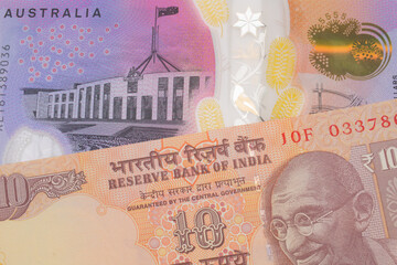 A macro image of a orange ten rupee bill from India paired up with a colorful five dollar bill from Australia.  Shot close up in macro.