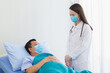© nut_foto - An Asian woman doctor is talking about health with a man patient at  the hospital. Both wear a surgical mask to protect Corona virus epidemic. Coronavirus protection concept.