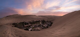 Fototapeta  - Oasis Huacachina, very close from Ica, just a few minutes before the blue hour s. Oasis Huacachina, very close from Ica, just a few minutes before the blue hour start among the sand dunes.
Huacachina,