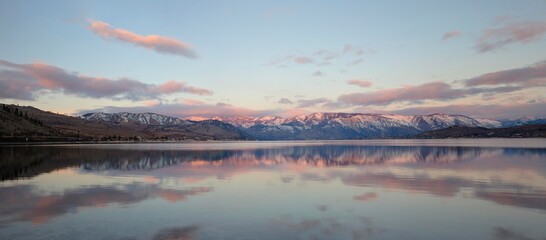 Wall Mural - Sunrise over lake Chelan in eastern washington with the snowy cascade mountains in the background. lonely, single desolate area