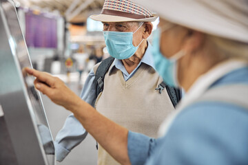 Wall Mural - Elderly tourist couple checking in their baggage