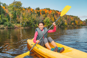 Kayak fun water sports down on river in Laurentians, Quebec. Canada travel destination. Woman kayaker kayaking in Mont-Tremblant during autumn.