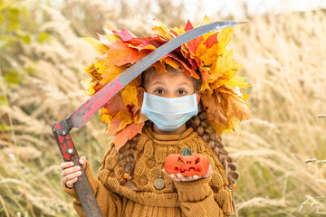 Wall Mural - Little girl with a scythe and a pumpkin in her hands for the Halloween holiday.