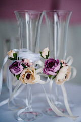 Two Wedding glasses are decorated with flowers. Close up.