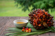 © MERCURY studio - Fresh palm oil fruits and cooking palm oil on a palm leaves in wooden background
