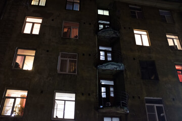 Poster - glowing windows in a residential multi-storey building at night