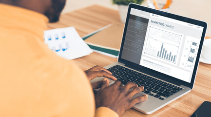 Poster - Businessman At Laptop Working With Internet Marketing Charts In Office