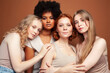 © iordani - young pretty african and caucasian women posing cheerful together on brown background, lifestyle diverse nationality people concept