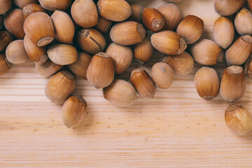 Pile of nuts. Whole nuts. Corylus avellana. Macro photo, close up, top view on wooden table.