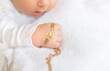The sacrament of the baptism of a child. The kid is holding a cross. Selective focus.