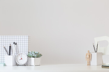 Desk at home office with supplies and wall copy space. Minimalistic workspace.