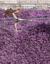 Woman Dancing Surrounded By Purple Flowers With A Flying Dress