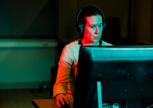 A Woman With Computer Mouse In Hand Works At Computer In Dark Room