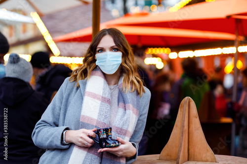Fotomural Woman with medical mask drinking hot punch, mulled wine on German Christmas market
