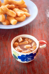 Wall Mural - Chinese bread stick or chinese donut in hot coffee. Breakfast street food usually eat with hot tea, coffee or soy milk.