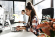 © BalanceFormCreative - Young female programmer sitting at the desk in her office and working .