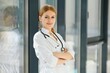 © Serhii - Portrait of young woman doctor with white coat standing in hospital