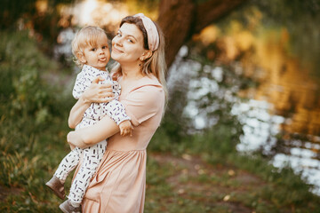 a mother holds her son in her arms on a summer day
