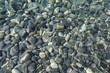 Top view of stones under water on shallow water on a sunny day in flat lay