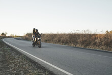 Couple Riding A Motorcycle On The Road