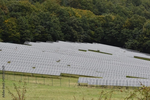 Solar panels placed on a meadow in dense rows, in Zarnovica, district town in Slovakia, Europe. An example of use of renewable resources for production or generation of electricity.