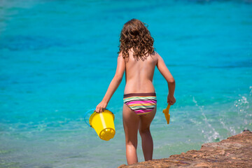 Kid girl rear view in beach tropical turquoise water