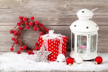 Burning lantern in the snow with christmas decoration, on wood b