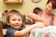 © Caro Telfer/Austockphoto - Young child sitting at table with mother and baby in background