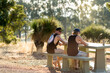 © Caro Telfer/Austockphoto - Back view of two guys sitting at a picnic table in a rural setting