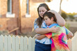 © Caro Telfer/Austockphoto - Two kids embracing outside an old house