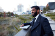 © Jonah Ritchie/Austockphoto - Indian architect with device surveying site