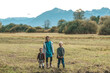 © Claudia - Kinder stehen auf dem Feld vor den Bergen