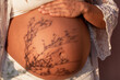 © Marta Nogueira - Naked belly of pregnant woman with shadow of plant. Maternity, pregnancy and motherhood concepts