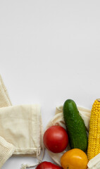 Bunch of mixed organic vegetables and empty reusable cotton bag on a table. Zero waste concept. Eco friendly lifestyle concept. Groceries and eco bags. Plastic free items. Reuse, reduce, recycle.