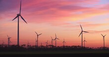 Neusiedl, Austria - November 22 2017: Windmills generating green energy by sunset at Neusiedl Weiden wind park in Austria.